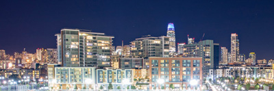 Nighttime view of Mission Bay campus with the San Francisco skyline in the background